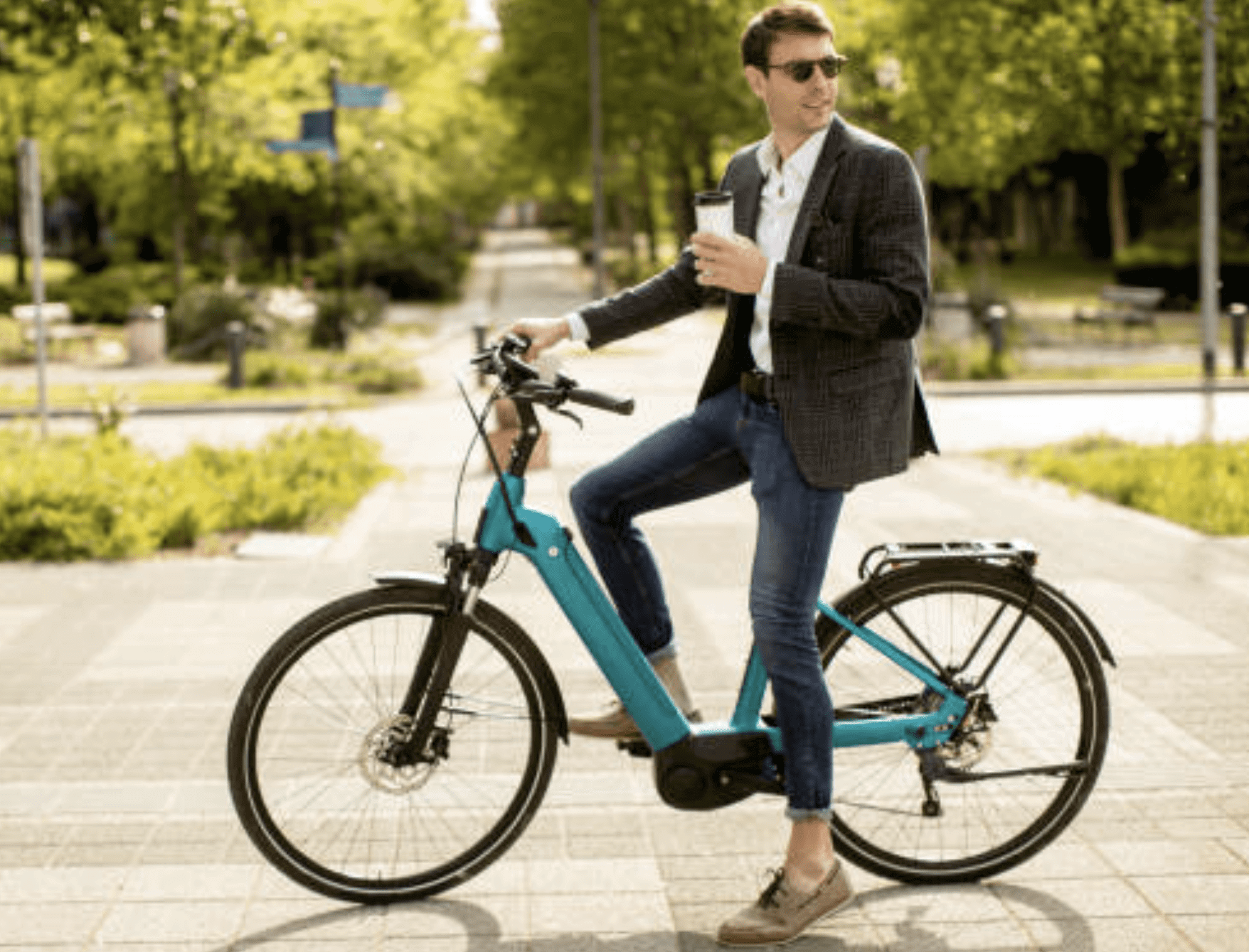 young man in an electric bike holding coffee in one hand